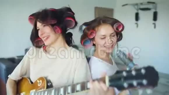 两个有趣的女孩用梳子唱歌弹电吉他跳舞在家唱歌玩得开心视频的预览图