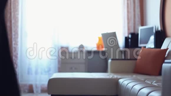 一大早年轻女子在客厅的沙发上扔衣服视频的预览图