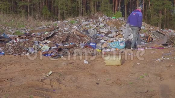 无家可归的人寻找有用的物品和食物以生存之间的垃圾垃圾堆环境视频的预览图