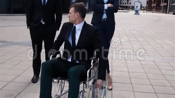 残疾人男子坐在轮椅上与同事背对背的史诗般的镜头视频的预览图