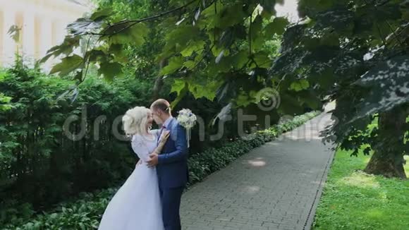 新婚幸福牵着手在公园散步拥抱亲吻视频的预览图