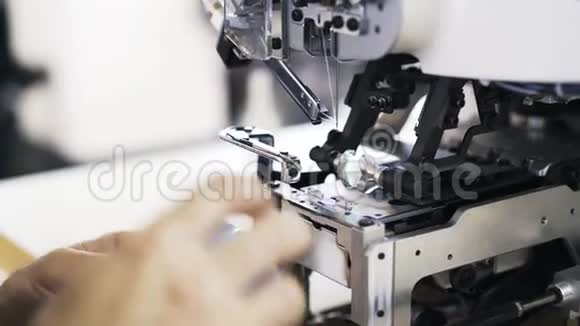 在工厂里把一个扣子系在衬衫上的工人视频的预览图