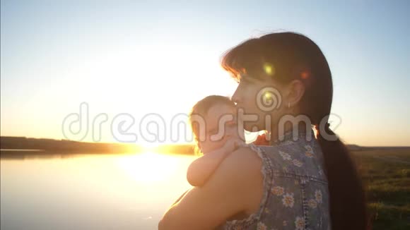 婴儿抱着年轻的母亲微笑着慢动作视频的预览图
