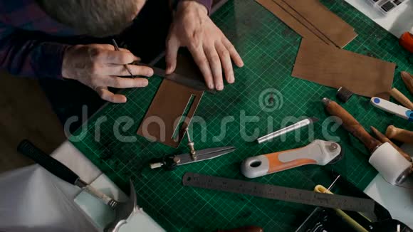 手工制作皮夹的过程工匠剪下一块皮手工皮革制品视频的预览图