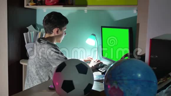 绿键少年玩电脑特写手游视频坐回室内这个男孩在电脑上工作视频的预览图