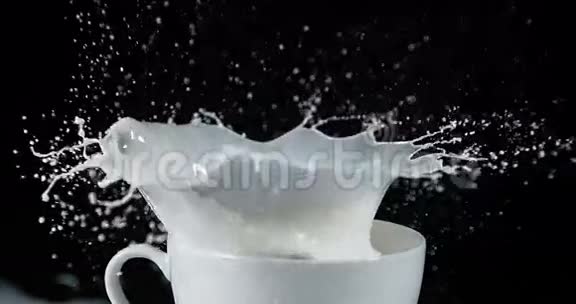 高尔夫球球在碗与爆炸牛奶对抗黑色背景视频的预览图