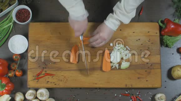 厨师切洋葱和胡萝卜洋葱和胡萝卜作为制作汤或其他菜肴的原料顶部视图视频的预览图