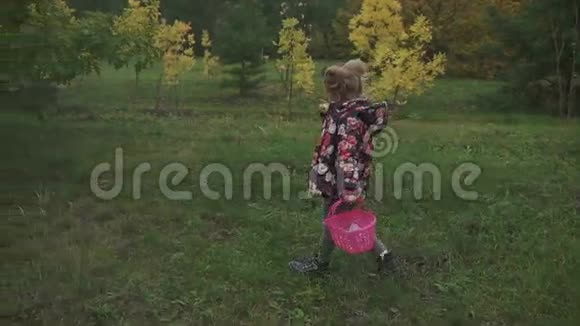 带着篮子在森林里散步的漂亮小女孩视频的预览图