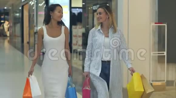 两位友好的女性在商场散步时聊天视频的预览图