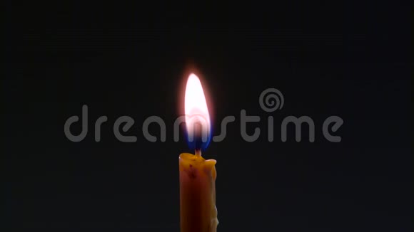 蜡滴在燃烧的蜡烛上黑色背景关门视频的预览图
