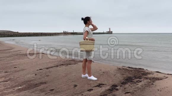 有篮子的女人在海边等着视频的预览图