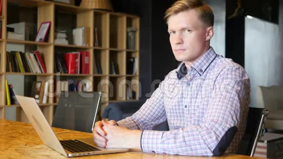 一位年轻的职业微笑男在办公室微笑的肖像视频的预览图