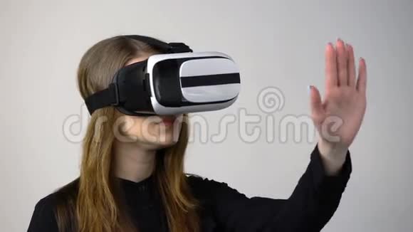 穿着虚拟现实护目镜的休闲年轻女子移动手视频的预览图