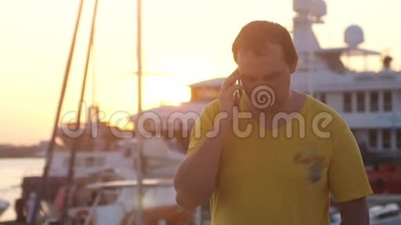 年轻人在日落的海上船只上用手机说话有镜头耀斑效应慢动作3840x2160视频的预览图