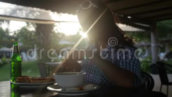嬉皮士女孩在餐厅吃比萨饼在日落时户外有镜头闪光效果3840x2160视频的预览图