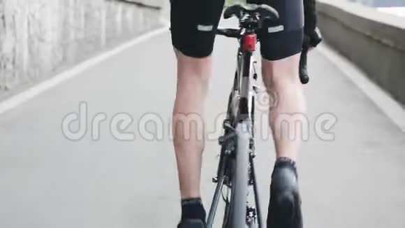 瘦小的骑自行车的腿与强壮的肌肉踏板上坡从马鞍骑自行车训练上坡自行车的概念视频的预览图
