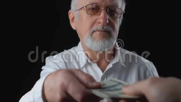 老人拿钱他数美元钞票薪金概念视频的预览图