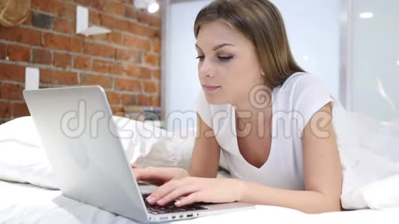 躺在床上工作的年轻女子视频的预览图