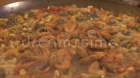 西班牙海鲜饭用米饭虾和蔬菜在平底锅中烹饪制作传统西班牙菜视频的预览图
