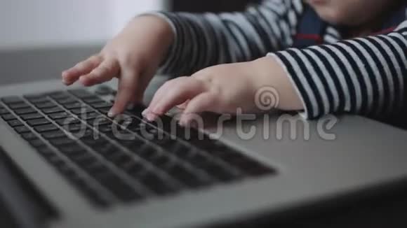幼儿的手触摸手提电脑键盘视频的预览图