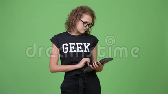 年轻快乐美丽的书呆子女人一边用数码平板电脑思考视频的预览图
