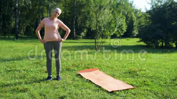 快乐的老年妇女在公园里做热身运动视频的预览图