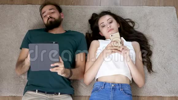 年轻男女躺在新公寓的地板上视频的预览图