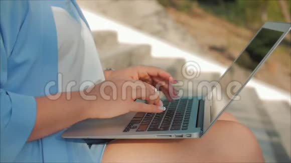 在笔记本电脑上工作的女人穿着蓝色西装带着笔记本电脑的漂亮黑发女人在电脑上工作的漂亮女人视频的预览图