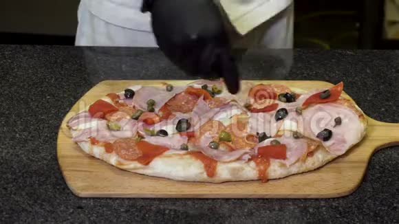 厨师戴着黑色烹饪手套在木板上做披萨美味的食物概念框架双手合拢视频的预览图