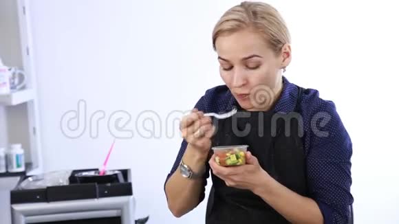 金发女郎在工作场所吃午饭理发师带饭盒视频的预览图