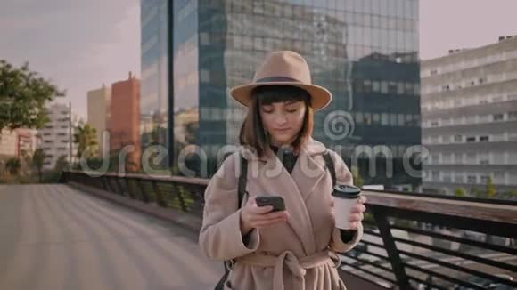在城市街头散步在户外使用现代智能手机的迷人年轻女商人的特写镜头阳光慢视频的预览图