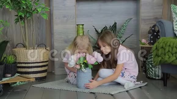 两个女孩在装饰着绿色植物的房间里玩耍两个姐妹玩得开心视频的预览图