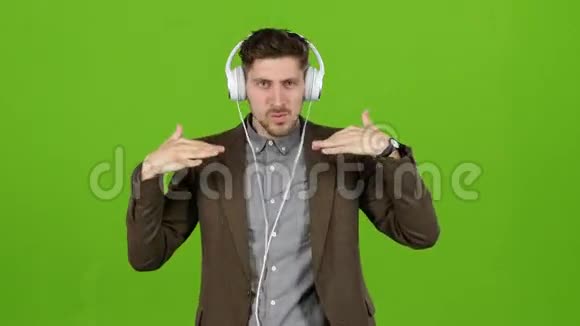 人类通过耳机听音乐跳舞和建立鬼脸绿色屏幕视频的预览图