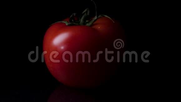 红色成熟番茄覆盖水滴分离在黑色框架番茄的黑色光泽背景视频的预览图