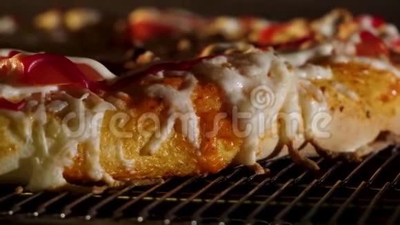 厨师把披萨面包放进燃烧的炉子里框架披萨店用绿色橄榄胡椒和奶酪做特写视频的预览图