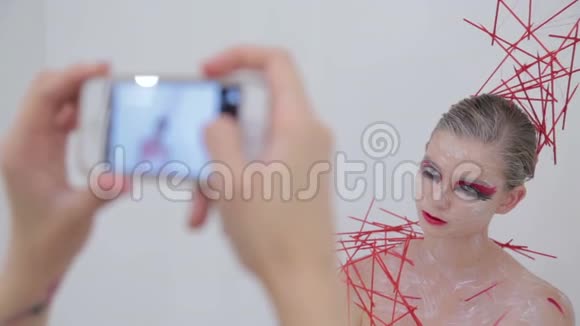 化妆师用创造性的不寻常的化妆给她的客户拍照视频的预览图