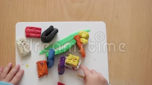 儿童手在用塑料制成的桌子上塑造雕像视频的预览图
