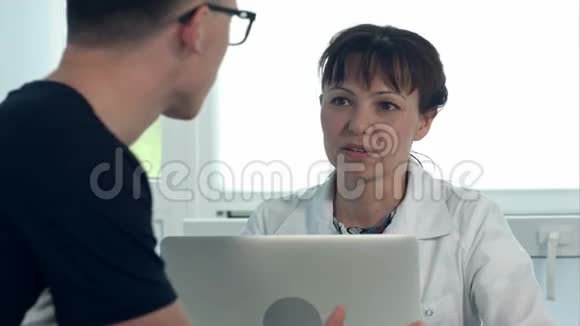 女医生和她办公室的男病人讨论诊断视频的预览图