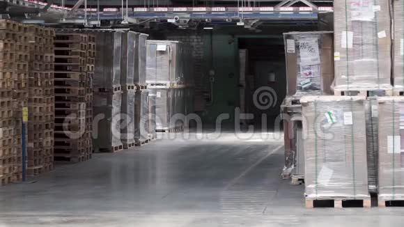 仓库有货架和货架装满纸板箱用铝箔包裹在木托盘上剪辑大而轻视频的预览图
