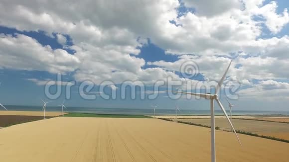 靠近大海的黄色草原背景上的风力涡轮机航空测量视频的预览图