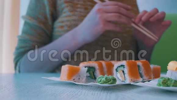 有筷子的女人从日本餐馆的盘子里取出寿司多利射击视频的预览图