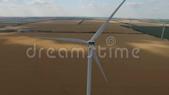 风力涡轮机的背景是黄色的麦田绿色的草地在海岸的顶部景色空中勘测关闭视频的预览图