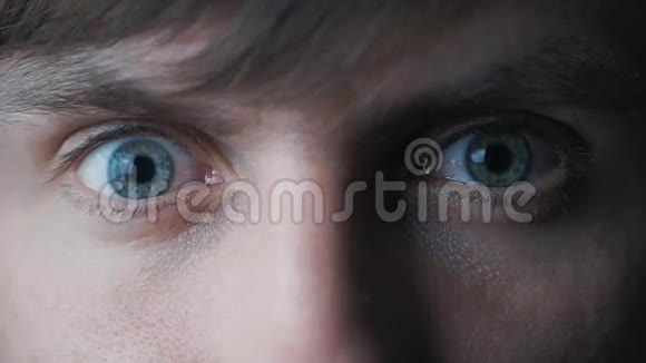 年轻人用蓝眼睛盯着镜头视频的预览图