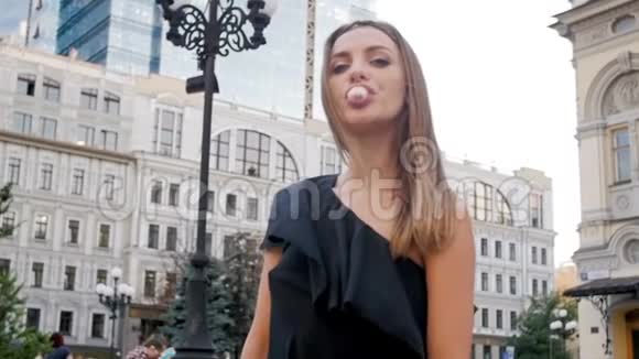 时尚年轻女性在城市街头嚼泡泡糖的特写视频视频的预览图