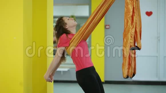 空中瑜伽的初学者用吊床做伸展胸部和背部的体式练习视频的预览图