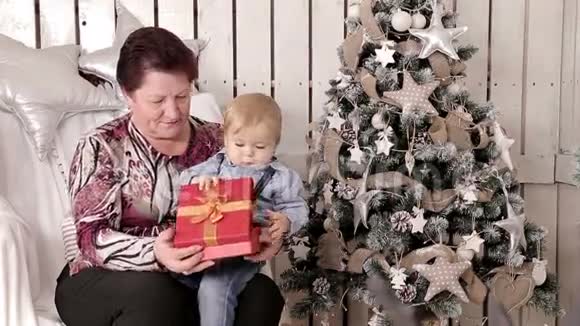 奶奶和孙子打开红色圣诞礼物视频的预览图