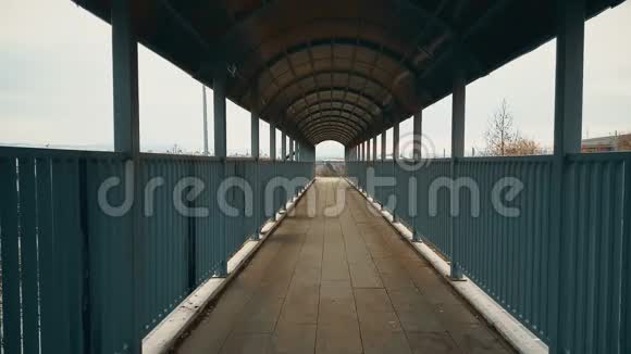 穿着黑色外套的跑步女子穿过人行天桥穿过高速公路视频的预览图