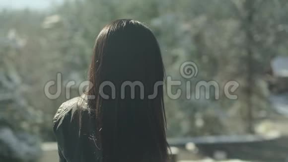 漂亮的拉丁女外套转向相机一幅长着棕色长发的女人在雪地里对着镜头微笑的肖像视频的预览图