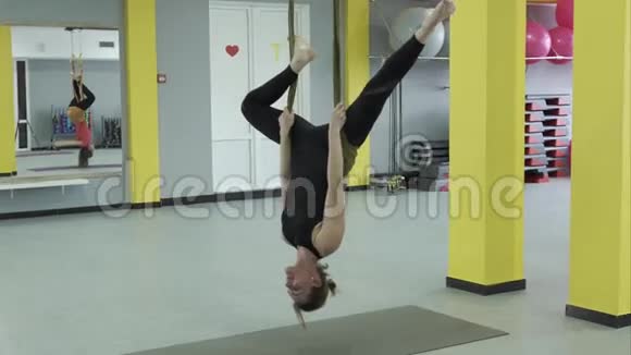 瑜伽大师做一个倒立的姿势挂在吊床上用于空中瑜伽视频的预览图