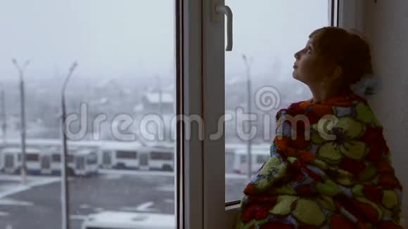 女孩望着窗外的雪视频的预览图